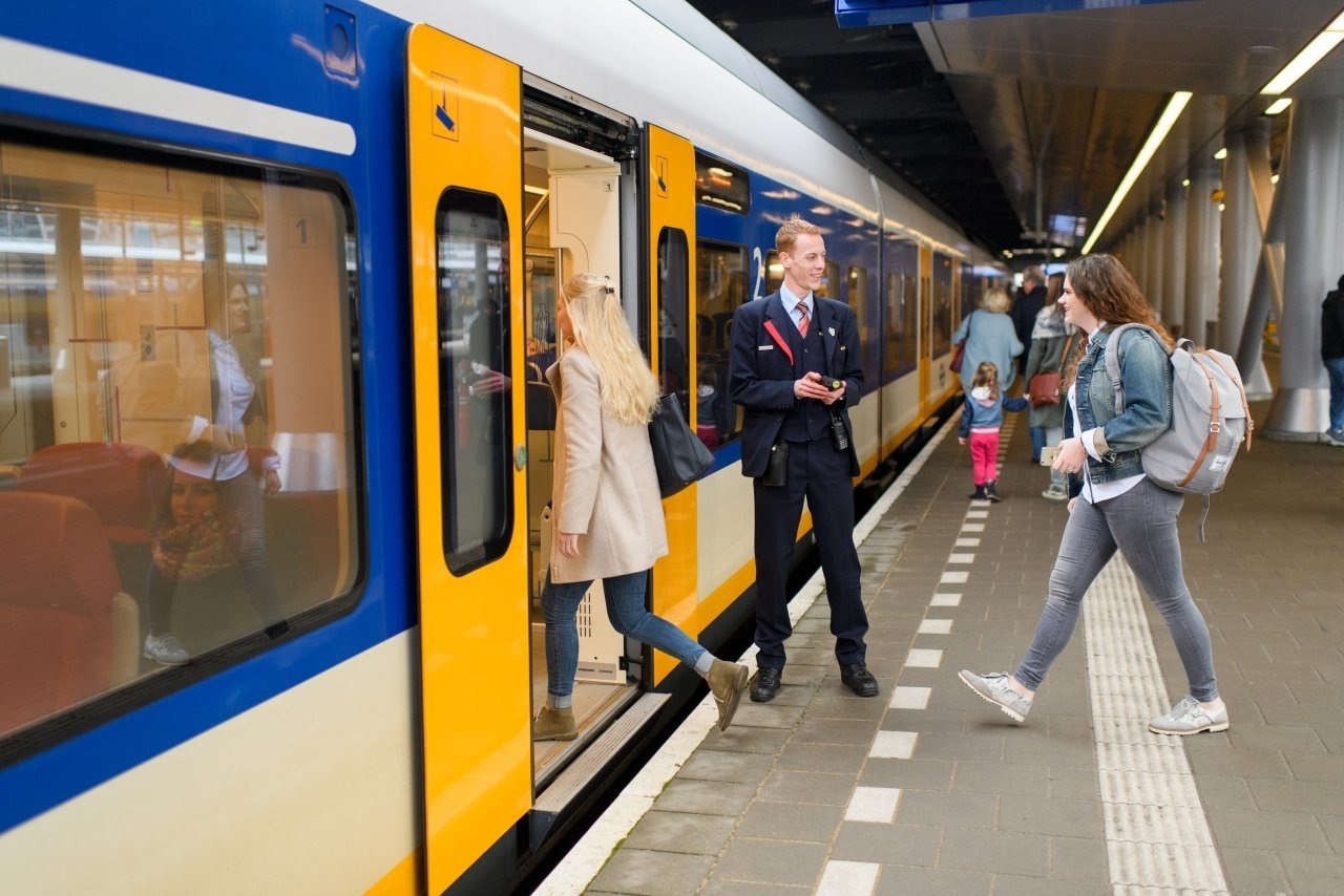 NS collega en reizigers op het perron